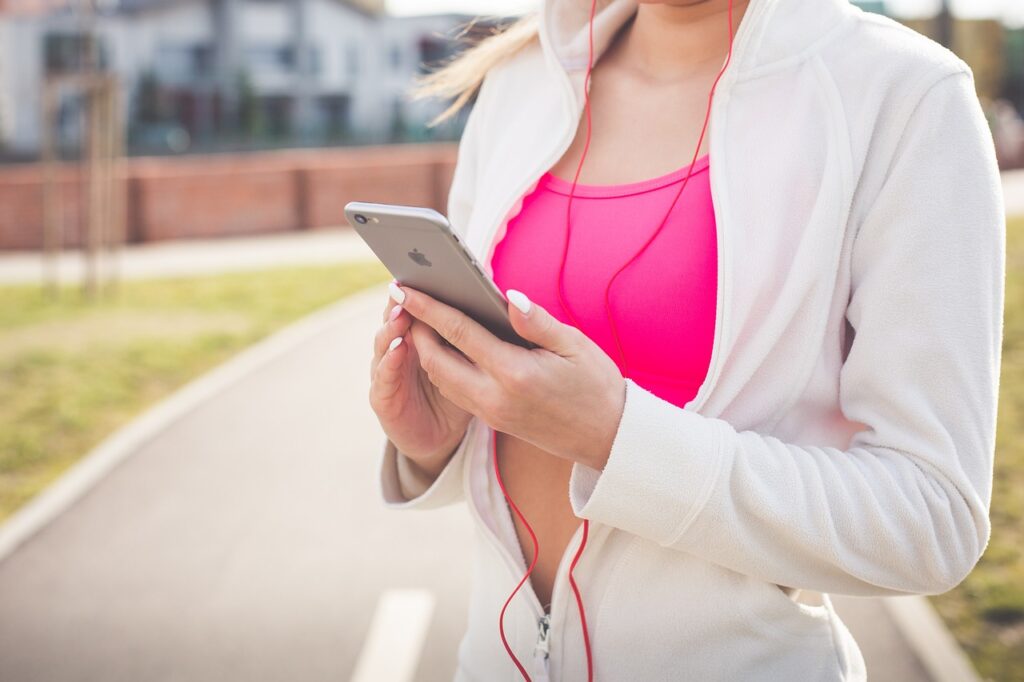 Femme fitness qui regarde un programme sur son smartphone